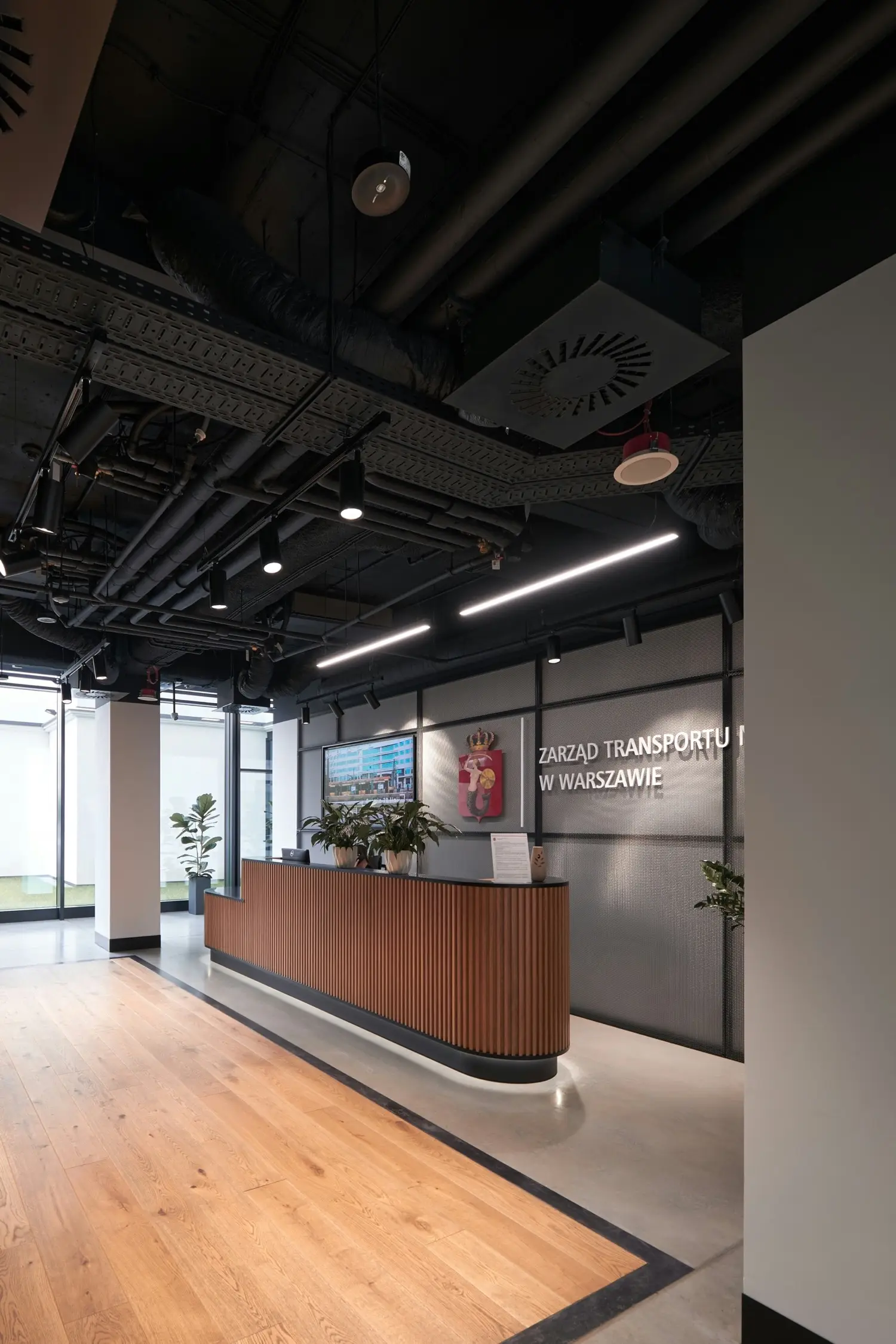 An empty office reception area with a wooden reception desk